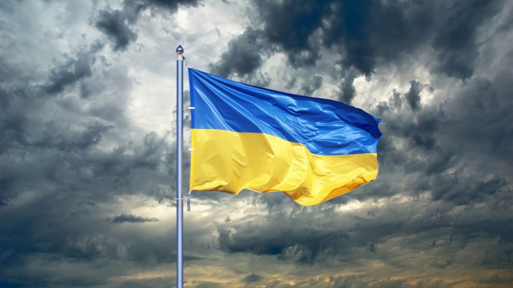 Ukraine flag flying in the sky with clouds in the background