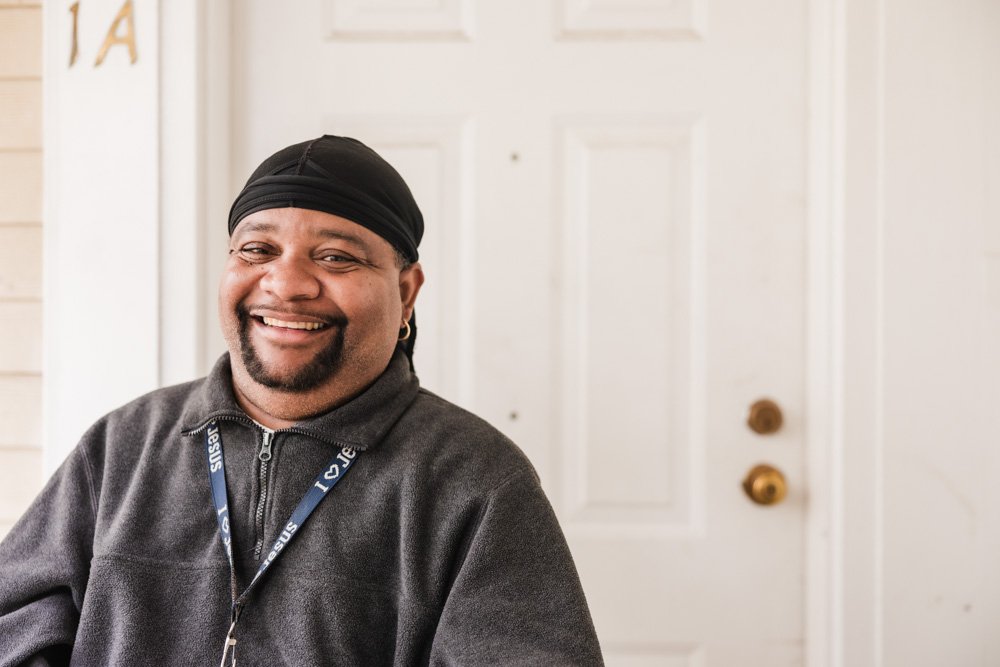 Angel smiling in front of his door