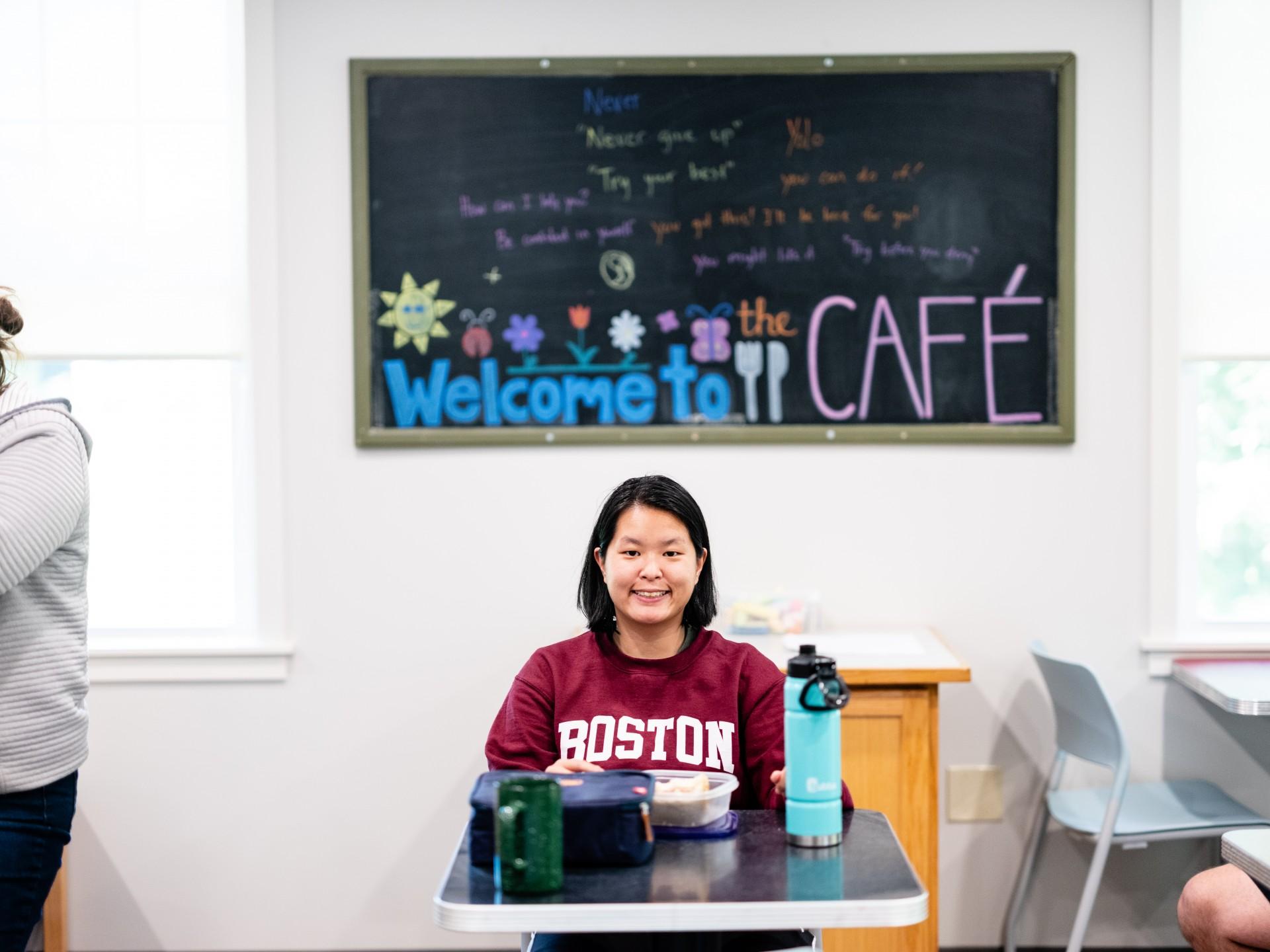 Image of woman sitting at cafeteria desk