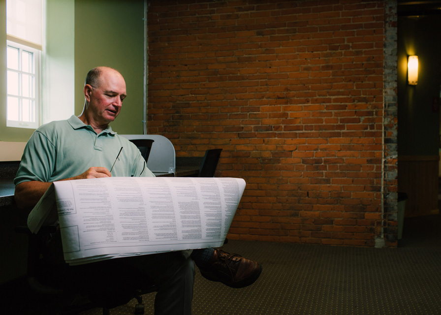 Peter looking at large document. 