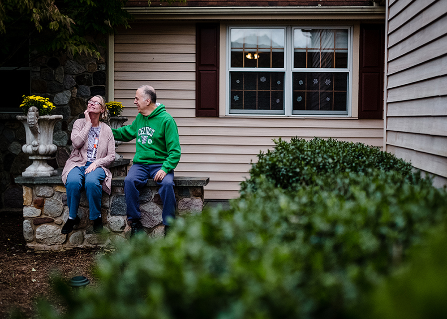 a man and a woman sitting together outside their community residence