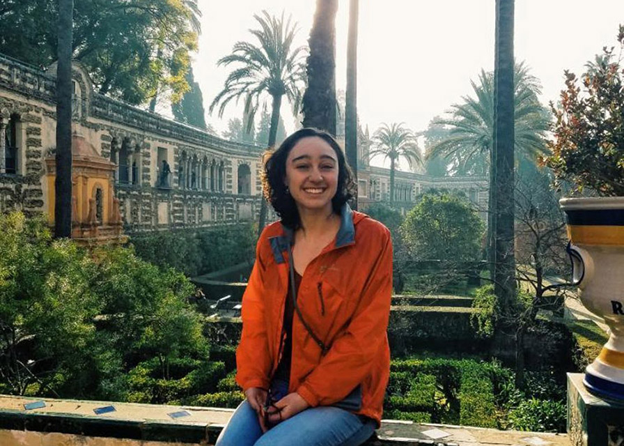 Lauren in front of a garden with palm trees