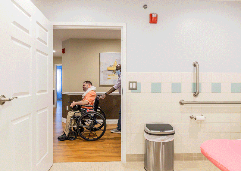 Man being wheeled through hallway