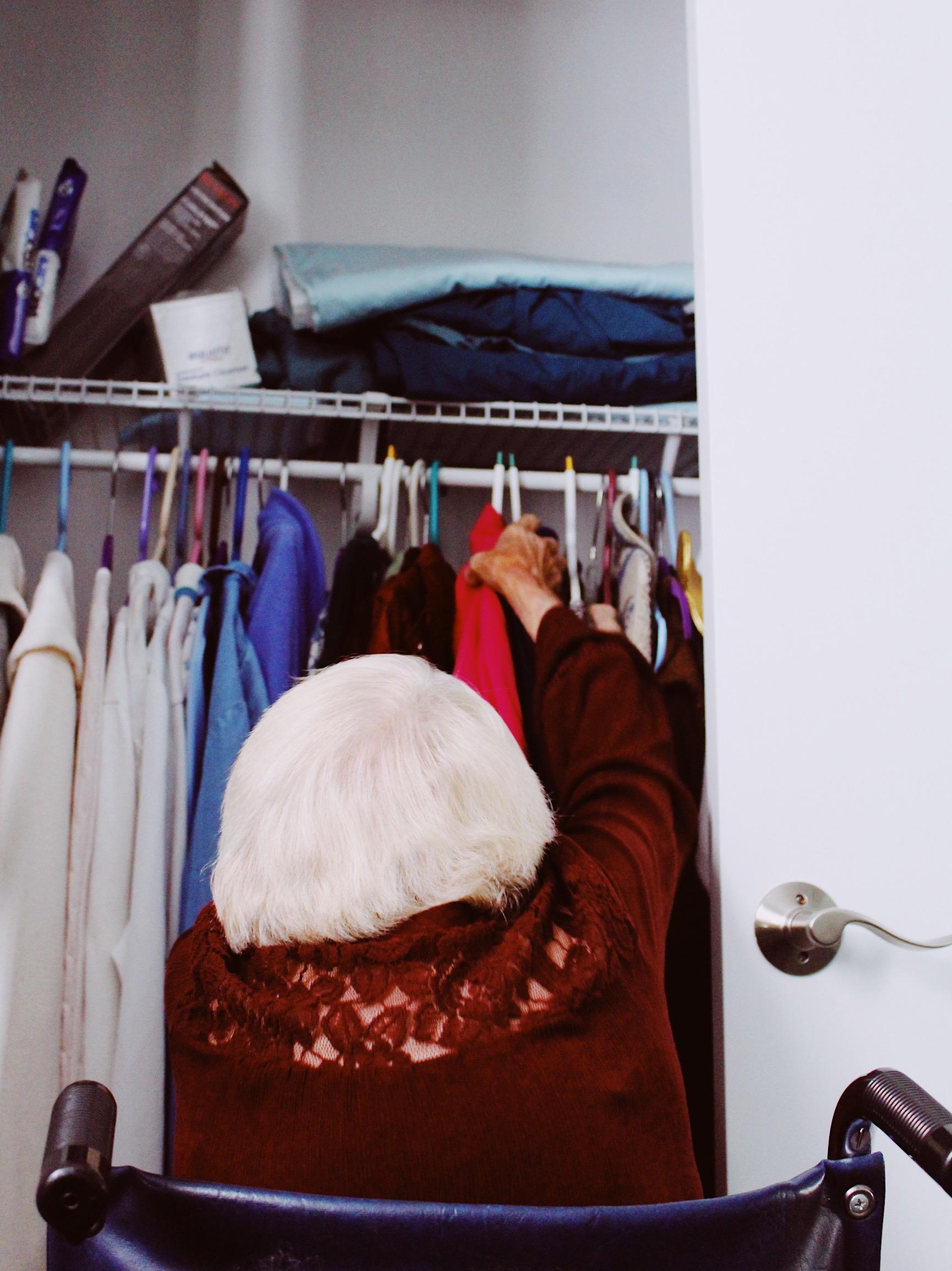 Woman in wheelchair reaching into closet