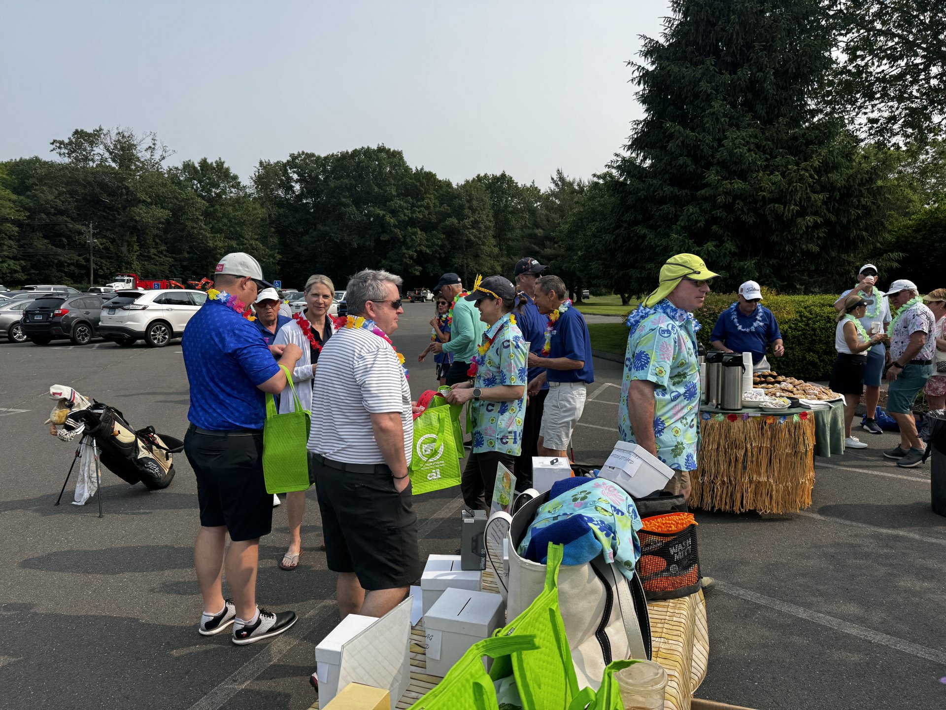Large group of individuals in a parking lot, chatting during registration